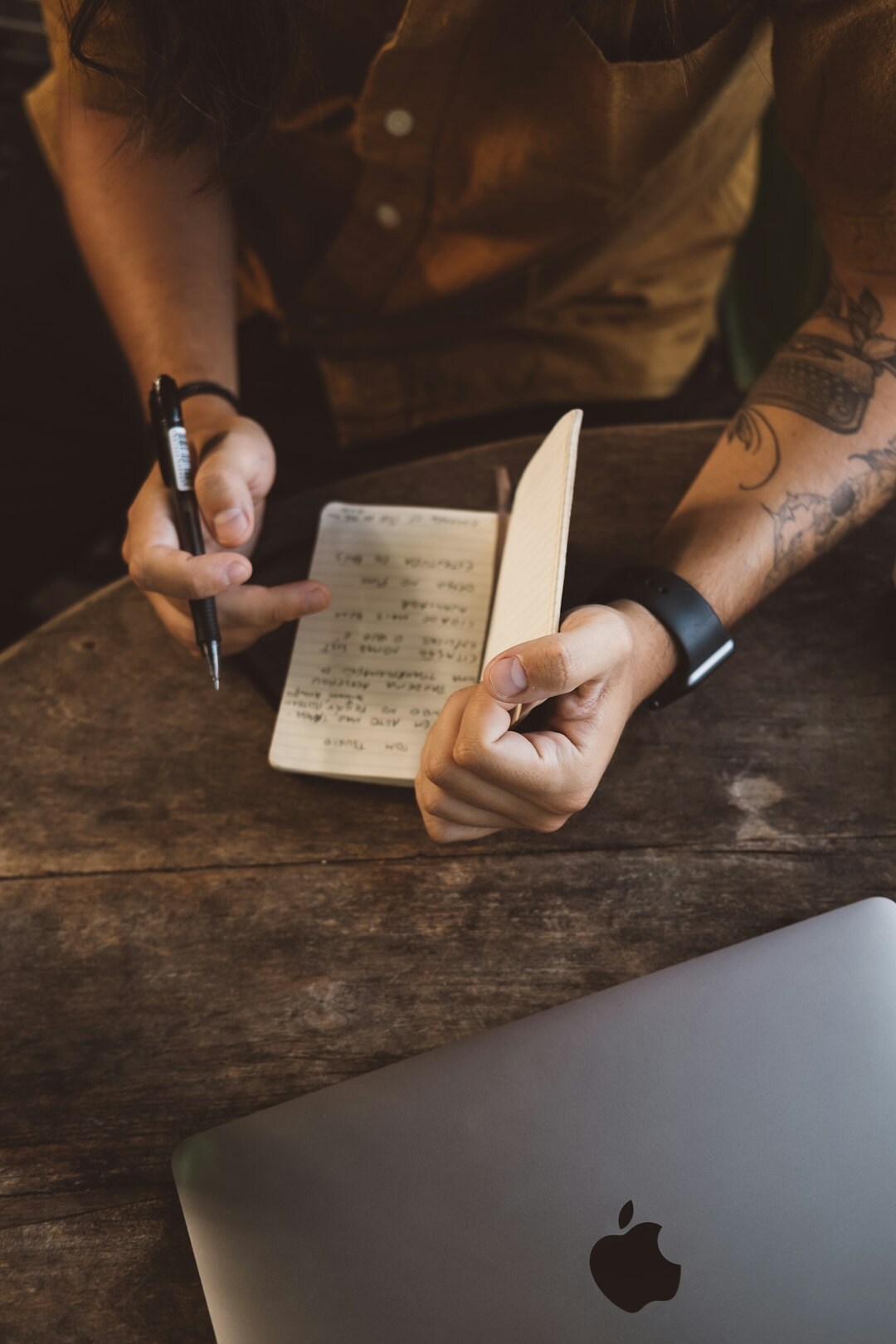 person writing goals in notebook