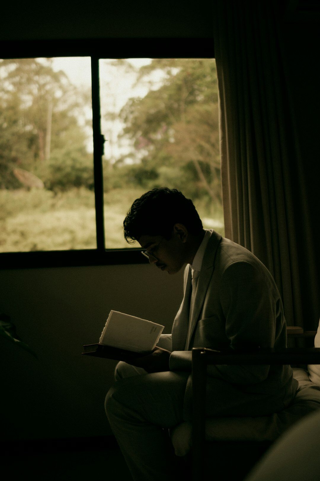 Person reading a book near a window