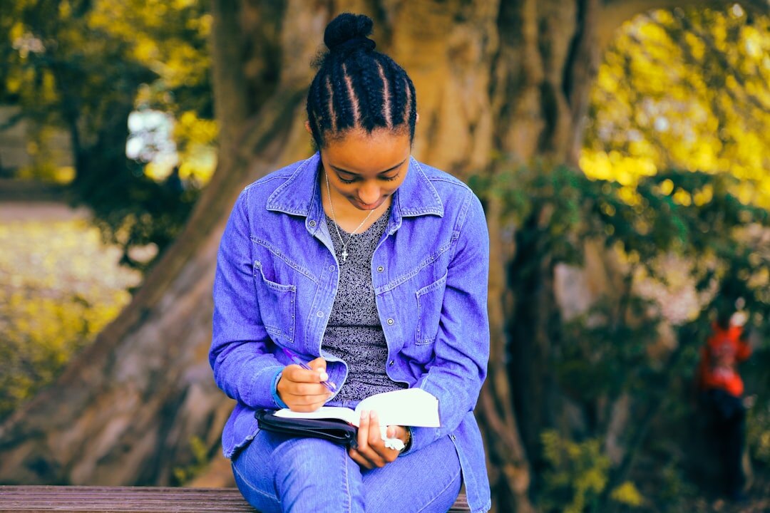 person writing in journal outdoors